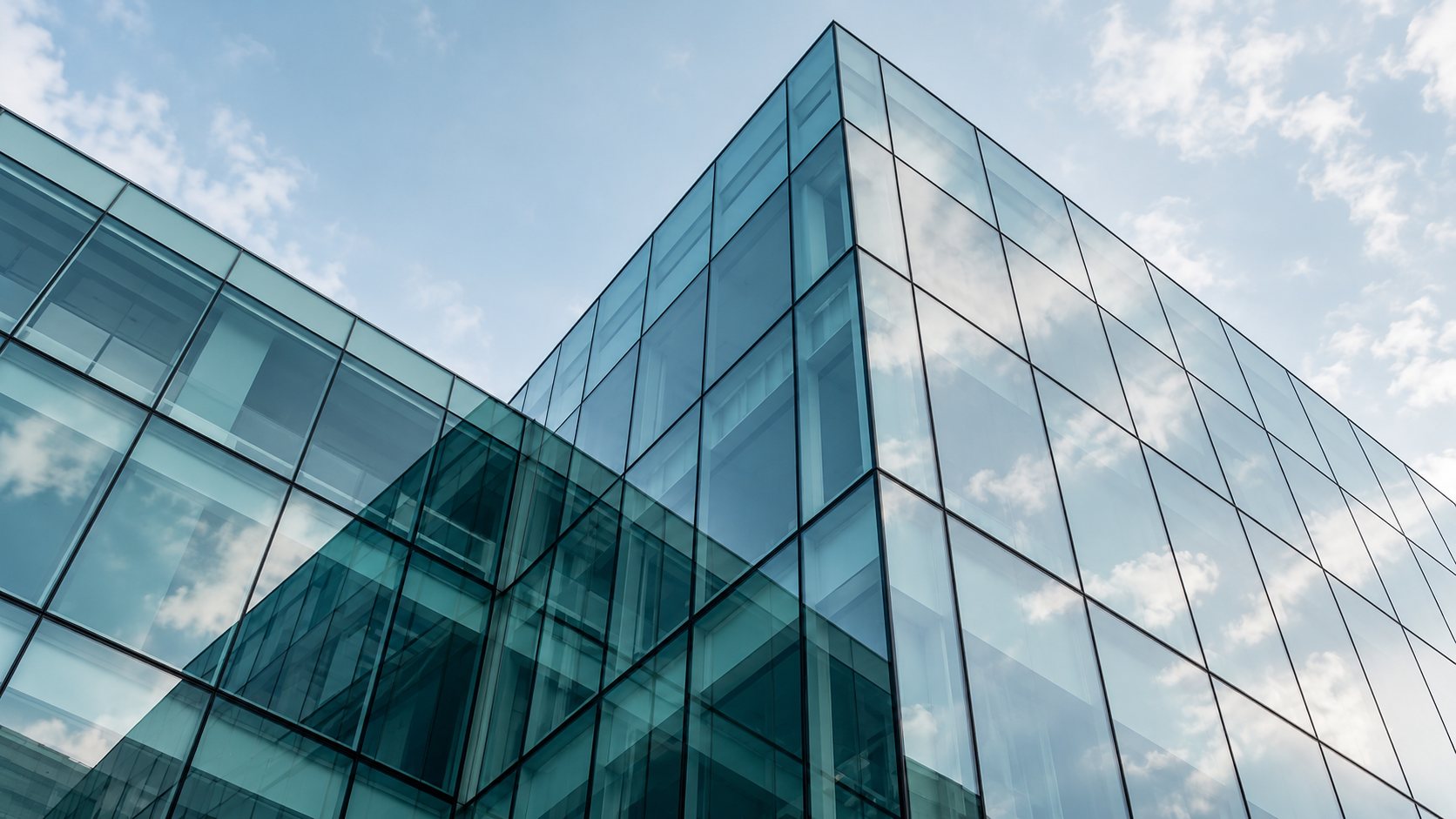 Illustration photographique : une façade vitrée d’immeuble de bureaux vue d’en bas.